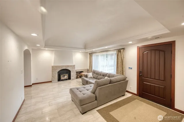 a living room with furniture a fireplace and a refrigerator