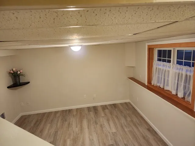 a view of a room with wooden floor and a window