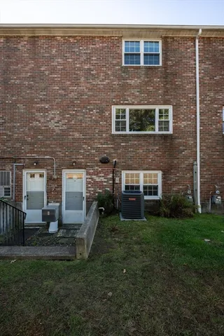 a brick house with a yard in front of it