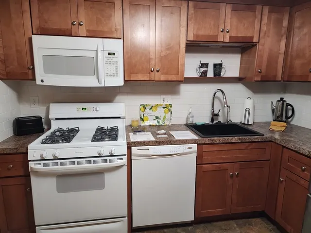 a kitchen with a stove a microwave and cabinets