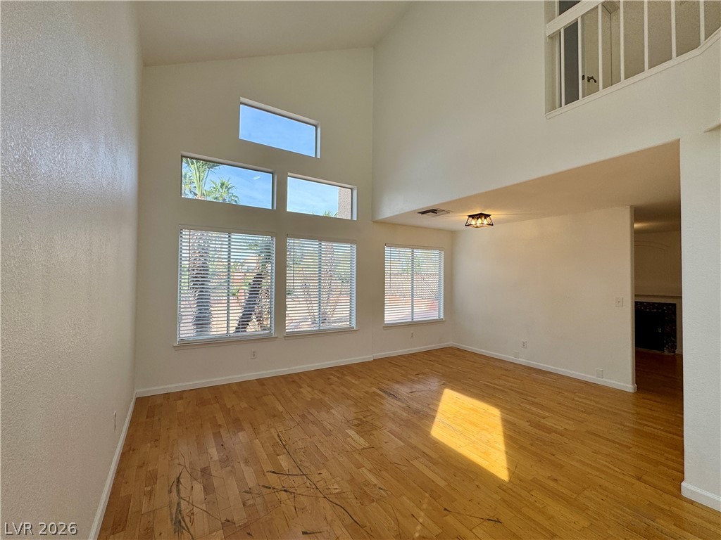 73 Sea Holly Way Henderson, NV 89074 - Photo 45 of 59 Unfurnished living room featuring light wood-type flooring and vaulted ceiling