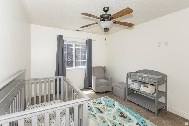 7797 North Windhover Road Eagle Mountain, UT 84005 - Photo 24 of 33 Bright interior space featuring a window with natural light, a ceiling fan with wood-finish blades, soft wall-to-wall carpeting, and neutral paint