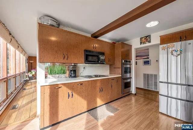 a kitchen with stainless steel appliances a refrigerator and a stove top oven