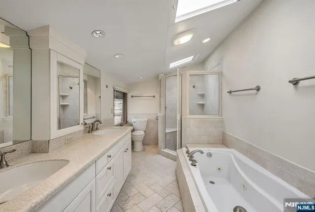 a bathroom with a granite countertop tub sink double vanity granite tub shower and mirror