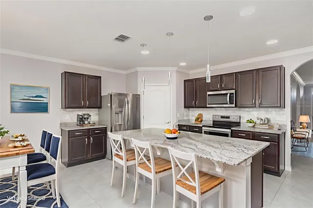 a kitchen with stainless steel appliances a stove a sink a microwave a refrigerator and cabinets