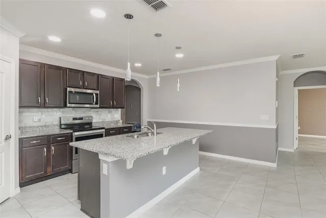 a kitchen with stainless steel appliances granite countertop a sink stove and refrigerator