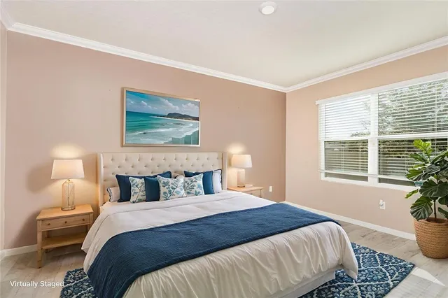 a bedroom with a large bed and a potted plant