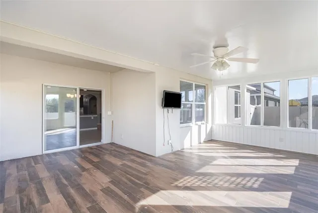a view of a livingroom with wooden floor and a ceiling fan