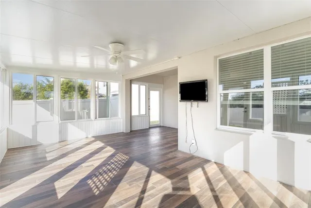 a view of a living room with flat screen tv and floor to ceiling window