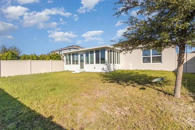 a view of a house with backyard and tree