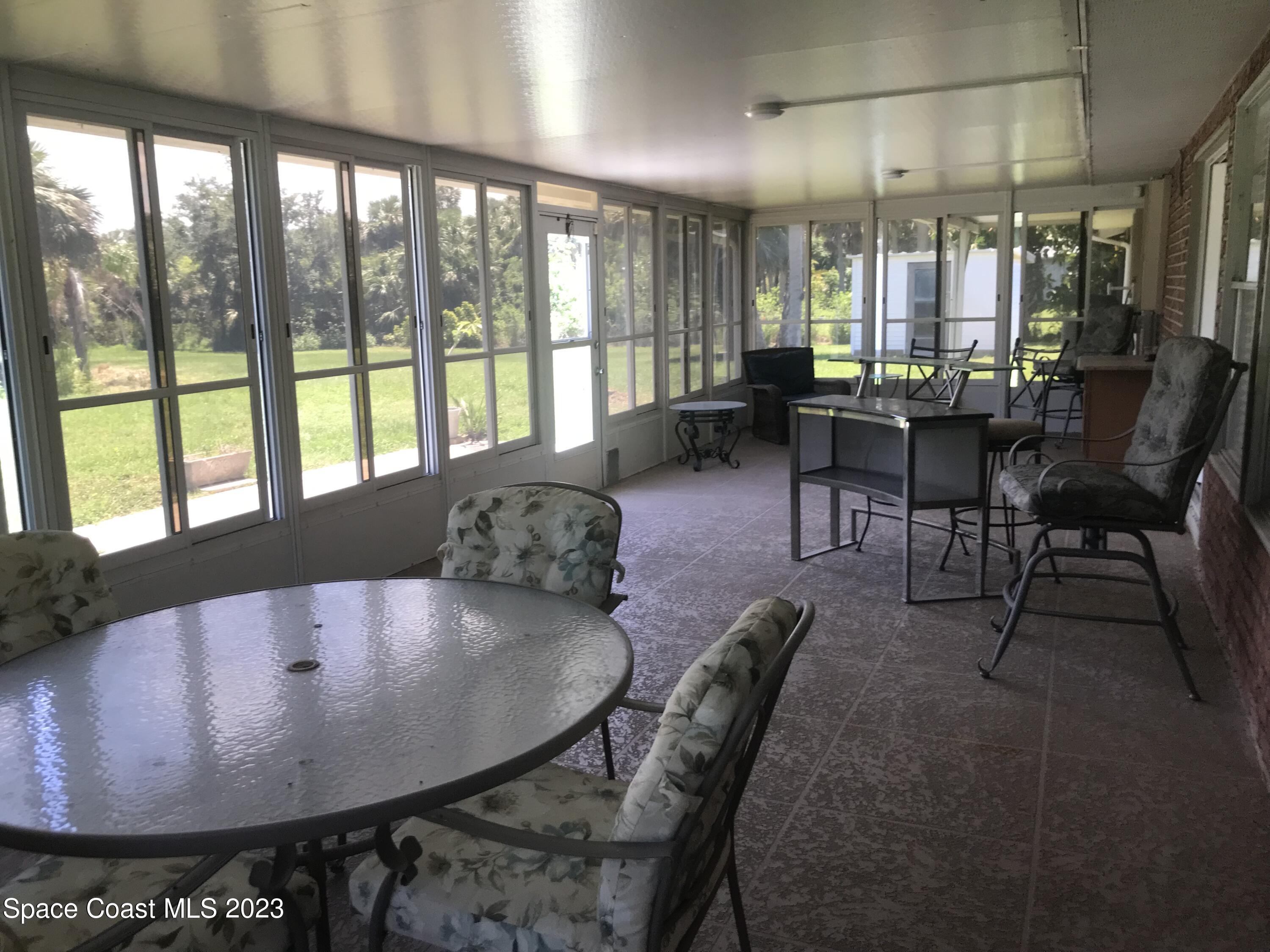 2525 Malabar Road Malabar, FL 32950 - Photo 18 of 30 a living room with furniture and a floor to ceiling window