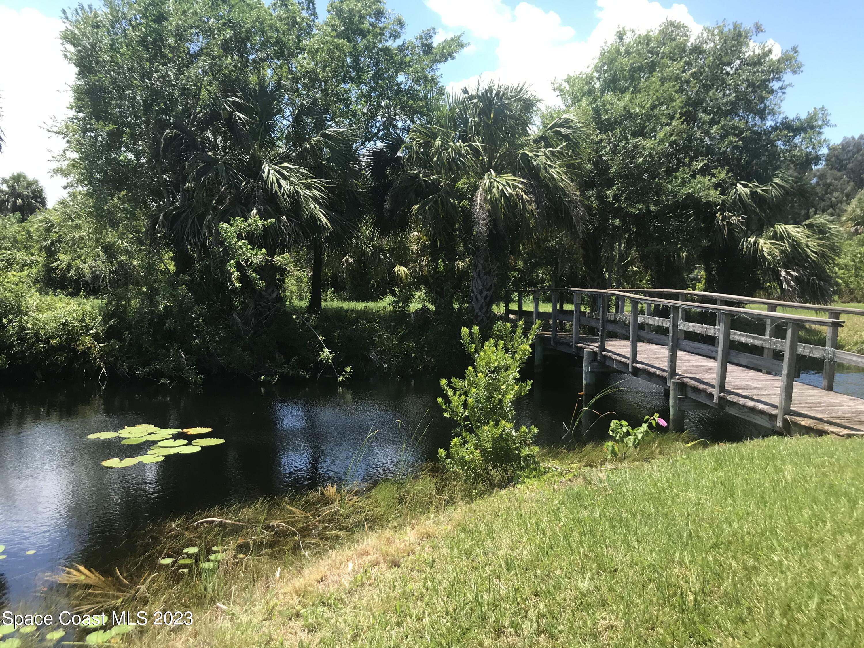 2525 Malabar Road Malabar, FL 32950 - Photo 22 of 30 a view of a lake with a bench and trees around