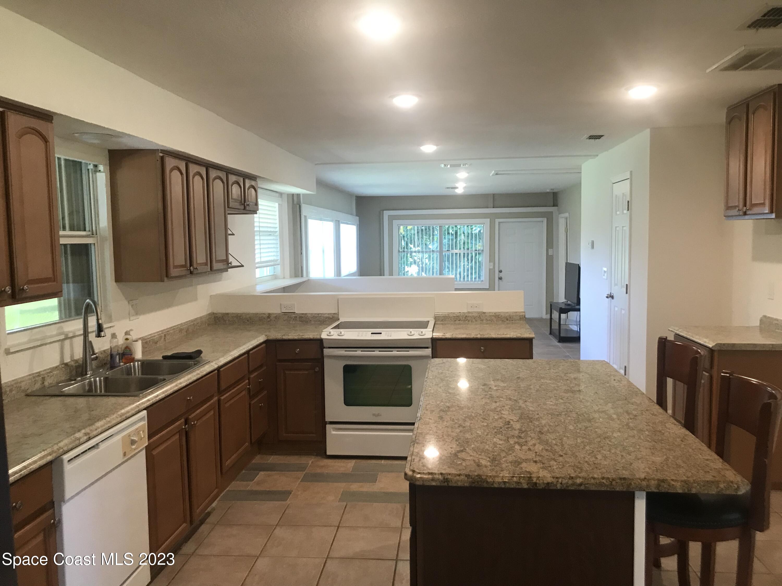 2525 Malabar Road Malabar, FL 32950 - Photo 7 of 30 a kitchen with stainless steel appliances granite countertop a sink stove and cabinets