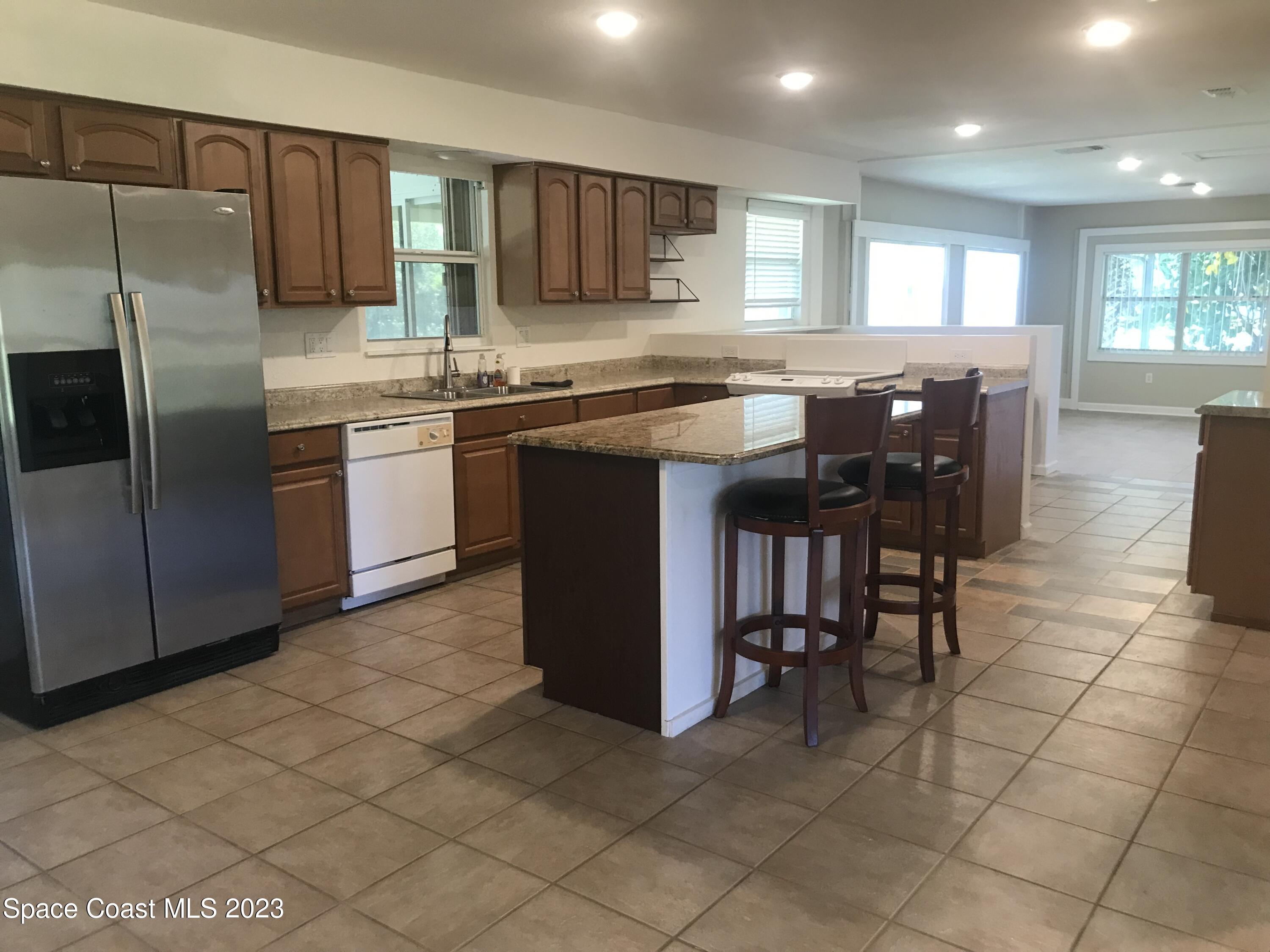 2525 Malabar Road Malabar, FL 32950 - Photo 8 of 30 a kitchen with stainless steel appliances granite countertop a stove a sink a microwave and a refrigerator