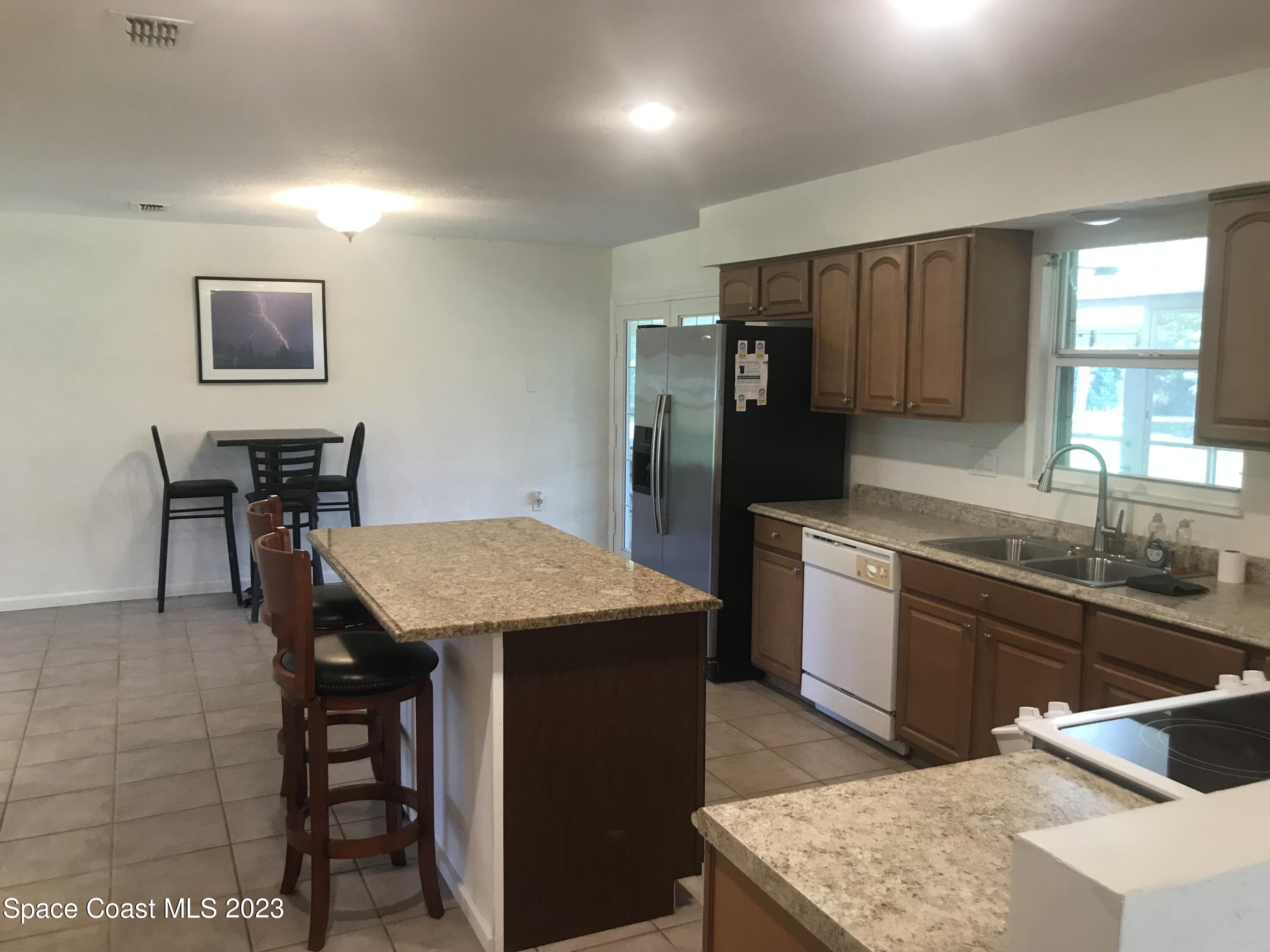 2525 Malabar Road Malabar, FL 32950 - Photo 9 of 30 a kitchen with a sink a counter top space and stainless steel appliances