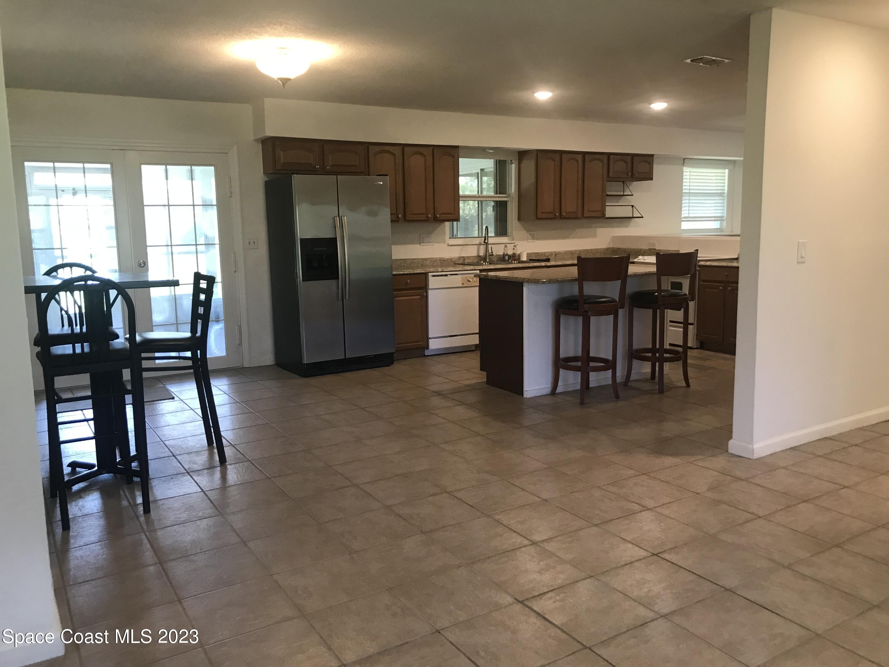 2525 Malabar Road Malabar, FL 32950 - Photo 10 of 30 a kitchen with stainless steel appliances kitchen island granite countertop a stove a sink a dining table and chairs