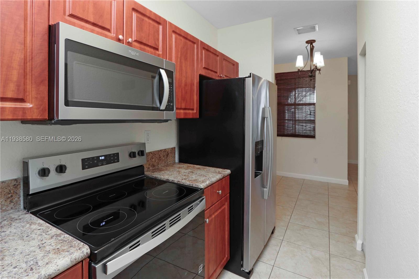 9219 Southwest 227th Street, Unit 9 Cutler Bay, FL 33190 - Photo 12 of 36 a kitchen with a stove microwave and refrigerator