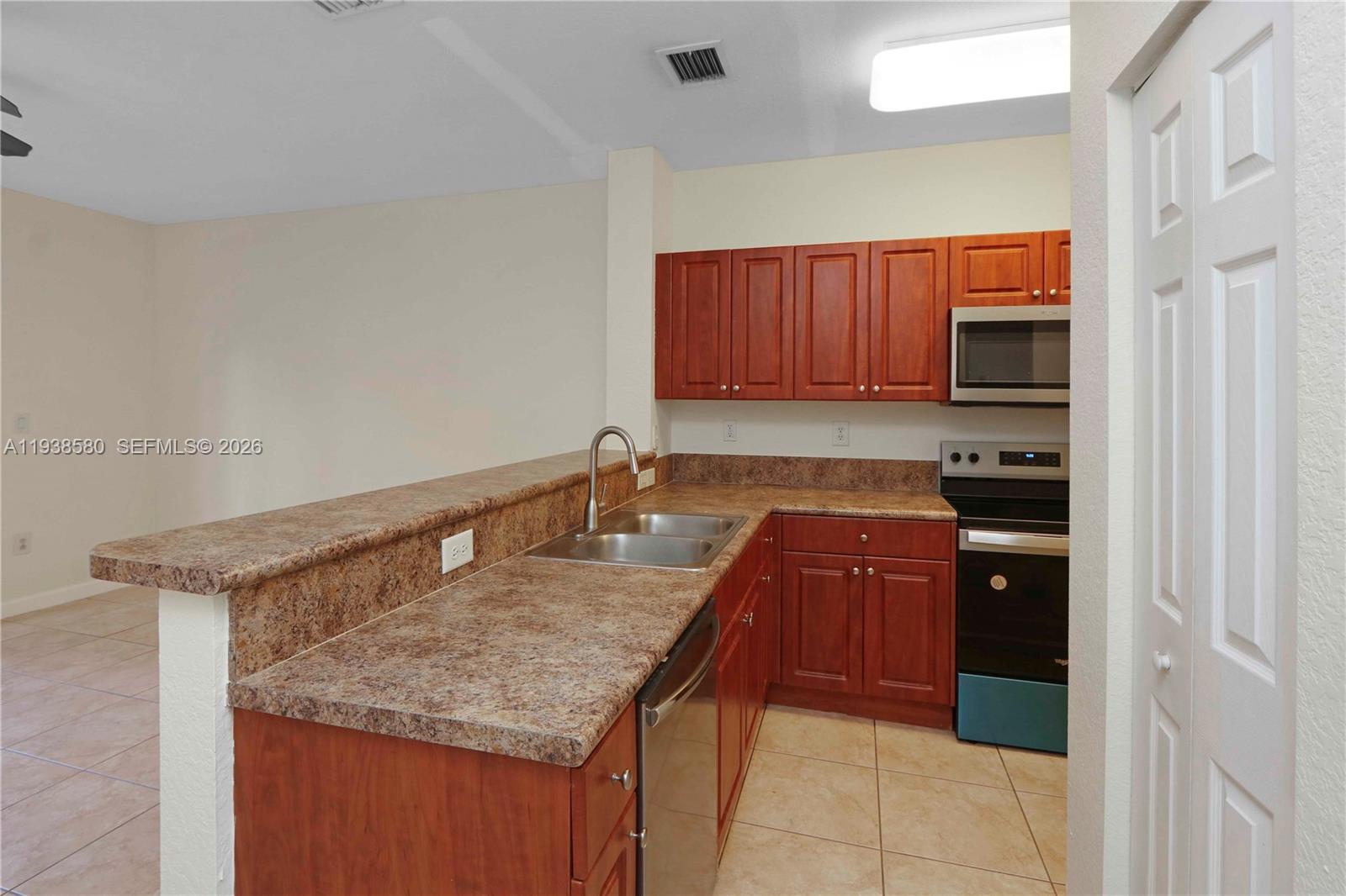 9219 Southwest 227th Street, Unit 9 Cutler Bay, FL 33190 - Photo 17 of 42 a kitchen with granite countertop a sink and cabinets