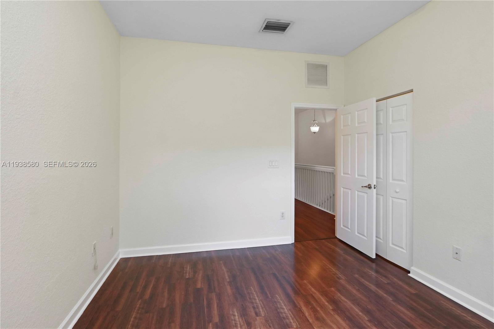 9219 Southwest 227th Street, Unit 9 Cutler Bay, FL 33190 - Photo 30 of 36 a view of a room with wooden floor and white doors