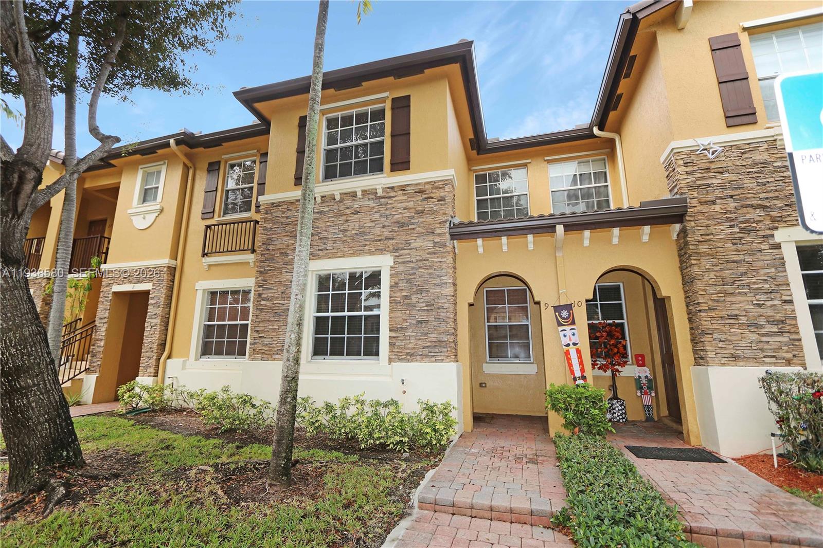 9219 Southwest 227th Street, Unit 9 Cutler Bay, FL 33190 - Photo 3 of 36 a front view of a house with garden