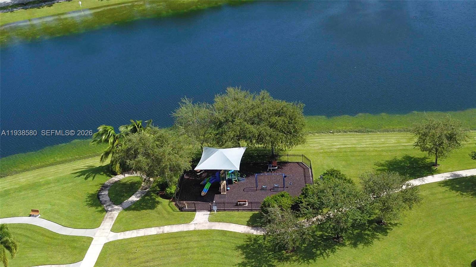 9219 Southwest 227th Street, Unit 9 Cutler Bay, FL 33190 - Photo 39 of 42 a backyard of a house with lots of green space and a lake view