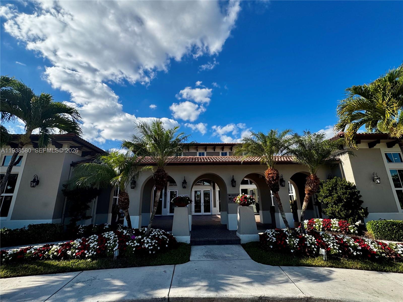 9219 Southwest 227th Street, Unit 9 Cutler Bay, FL 33190 - Photo 4 of 42 a front view of a house with lots of flowers and trees
