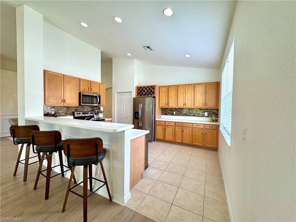 1905 Par Drive Naples, FL 34120 - Photo 7 of 30 a kitchen with stainless steel appliances kitchen island granite countertop a refrigerator a stove a sink dishwasher and a oven with cabinets