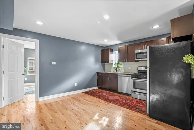 a kitchen with stainless steel appliances kitchen island granite countertop a refrigerator and a stove top oven