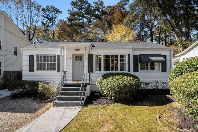 a view of a house with backyard and sitting area