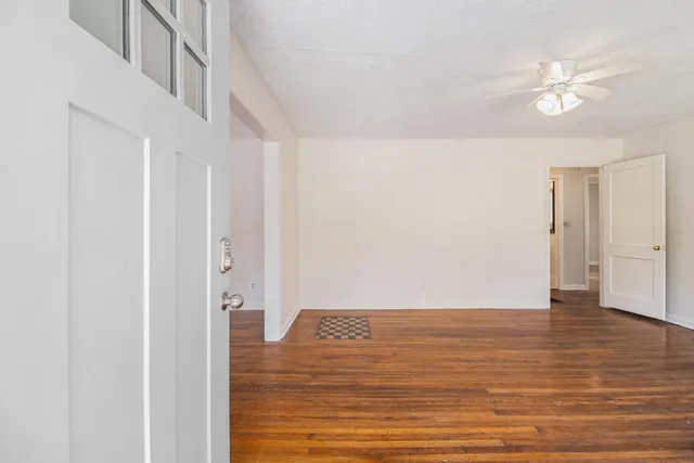 a view of an empty room with wooden floor