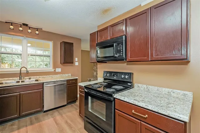 a kitchen with stainless steel appliances granite countertop a sink stove and microwave