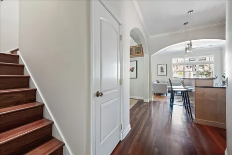 a view of a hallway with wooden floor and dining room