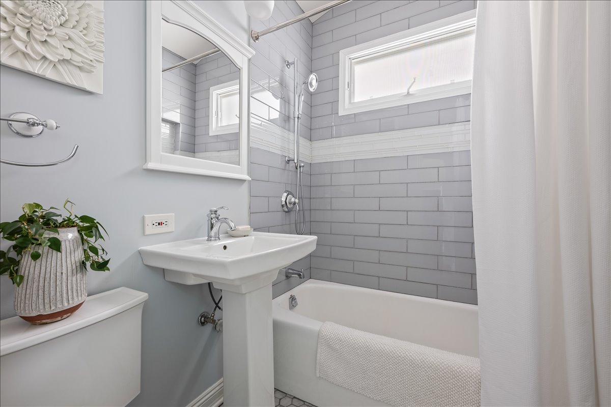 1332 West School Street Chicago, IL 60657 - Photo 21 of 45 a bathroom with a sink a mirror and a bathtub