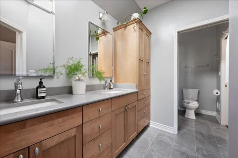 a bathroom with a granite countertop sink mirror and toilet