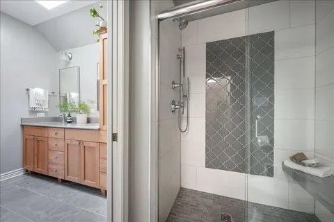 a bathroom with a granite countertop shower a sink and a mirror