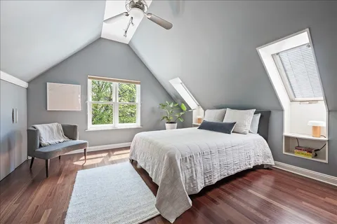 a bedroom with a bed wooden floor and window