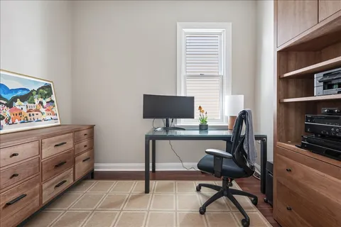 a view of a workspace with furniture and a window
