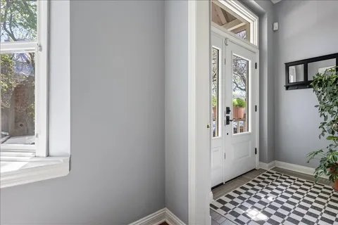 a view of a hallway with wooden floor and a bathroom