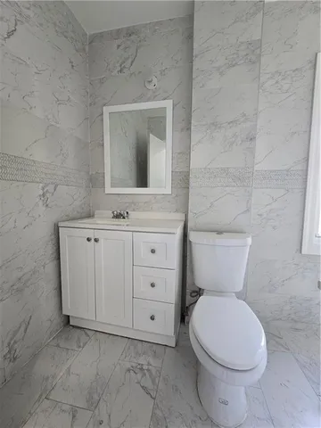 a bathroom with a toilet a sink and mirror