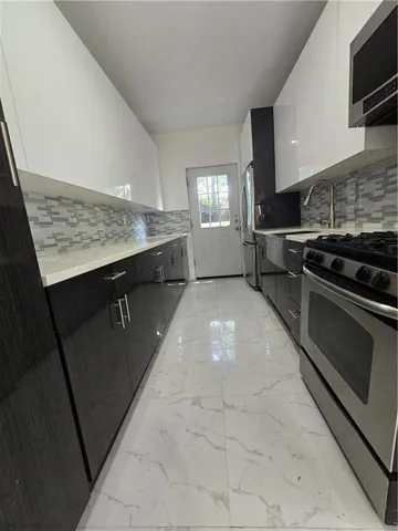 a kitchen with a sink stainless steel appliances and cabinets