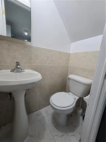 a bathroom with a sink toilet and a mirror