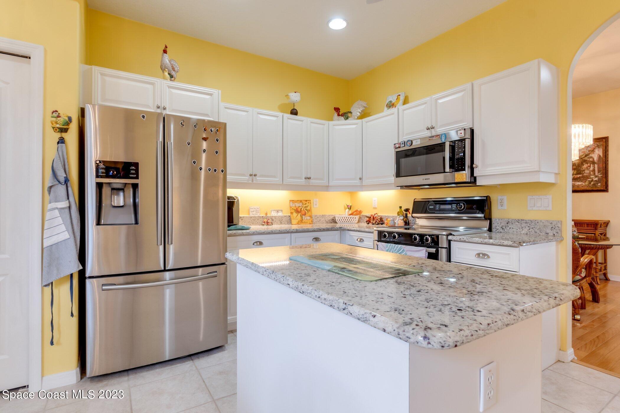 4370 Aberdeen Circle Rockledge, FL 32955 - Photo 13 of 58 a kitchen with stainless steel appliances granite countertop a refrigerator a stove a sink a microwave and cabinets