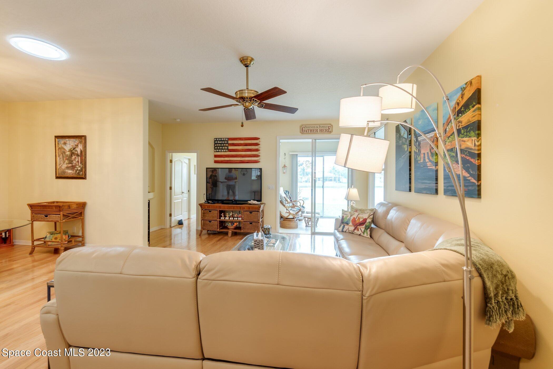 4370 Aberdeen Circle Rockledge, FL 32955 - Photo 18 of 58 a living room with furniture a chandelier and a flat screen tv