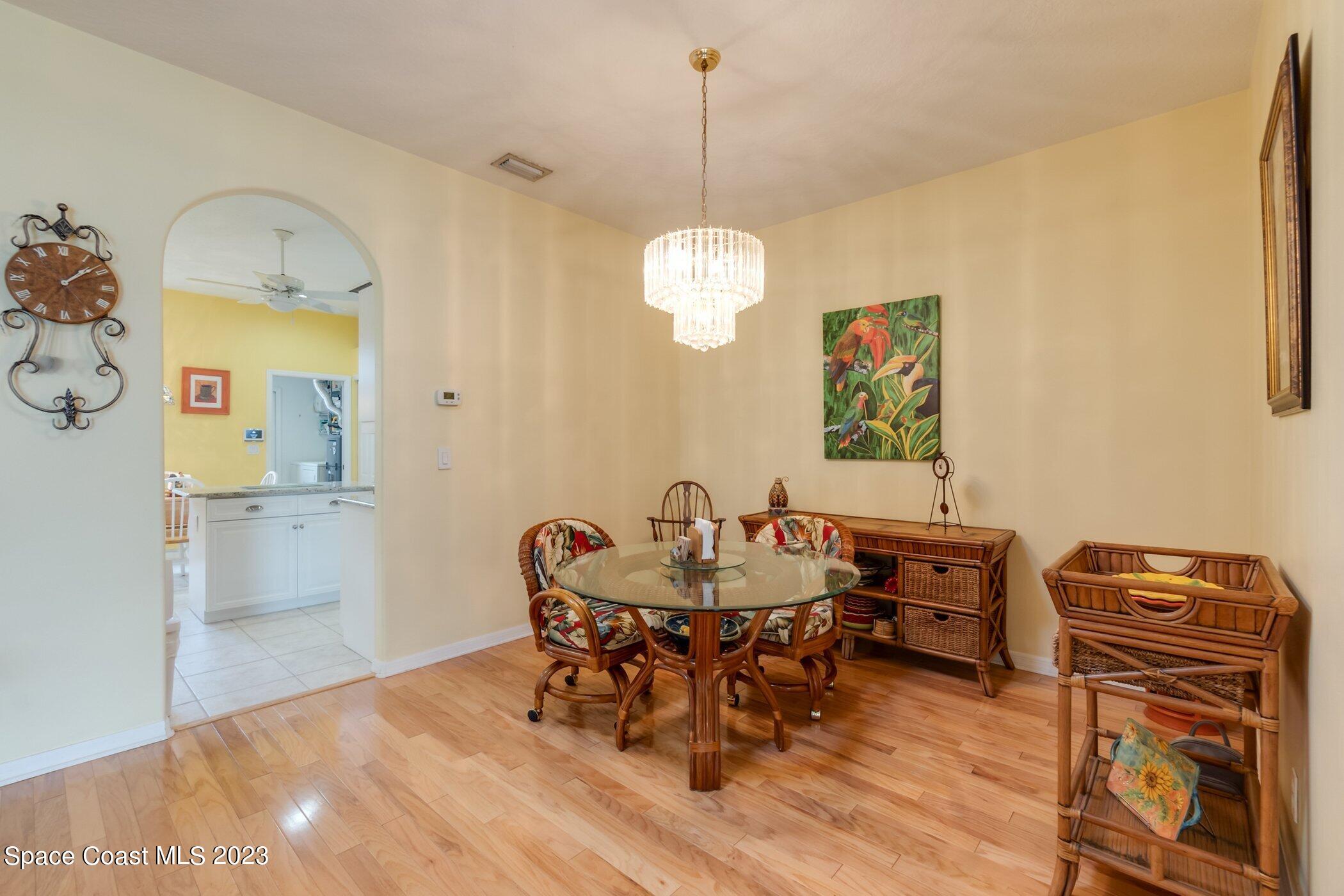 4370 Aberdeen Circle Rockledge, FL 32955 - Photo 26 of 58 a dining room with furniture a chandelier and wooden floor
