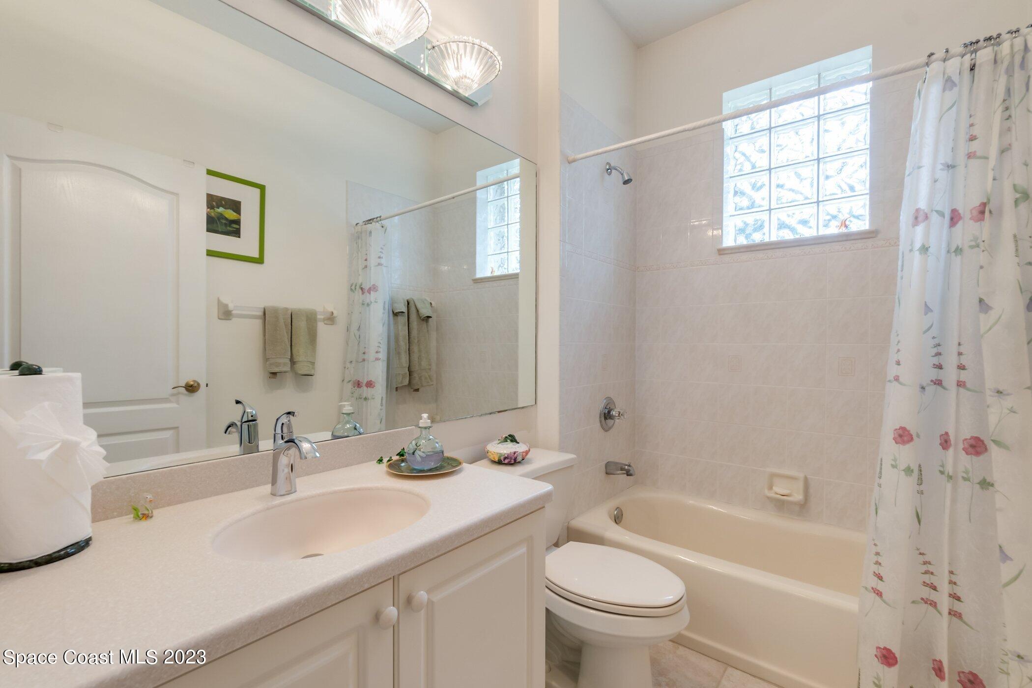 4370 Aberdeen Circle Rockledge, FL 32955 - Photo 37 of 58 a bathroom with a sink a toilet a mirror a bathtub and shower