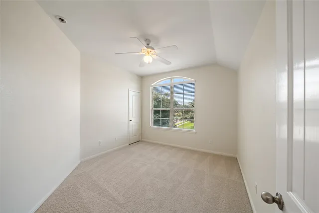 an empty room with windows and fan