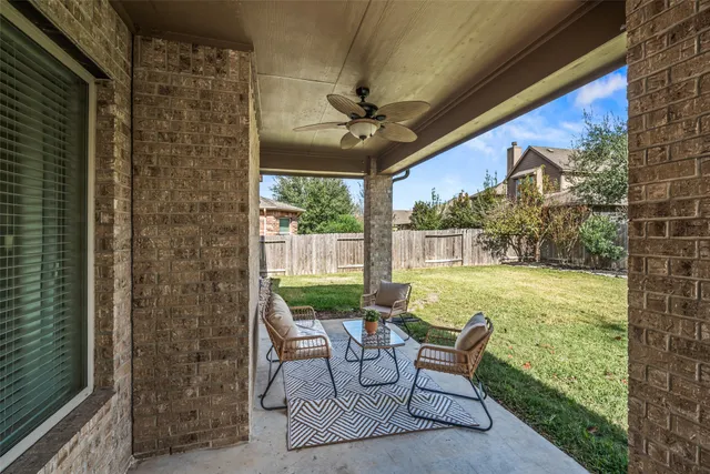 a view of a patio with table and chairs potted plants with floor to ceiling window