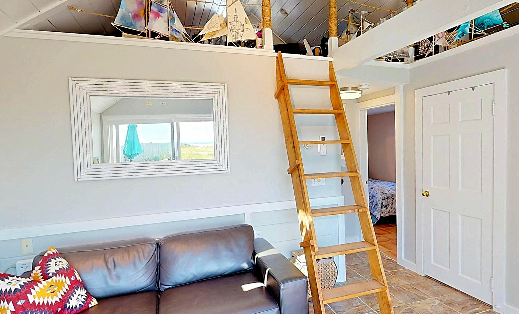 596 Shore Road, Unit H Truro, MA 02666 - Photo 16 of 30 a living room with a baby crib furniture and a chandelier