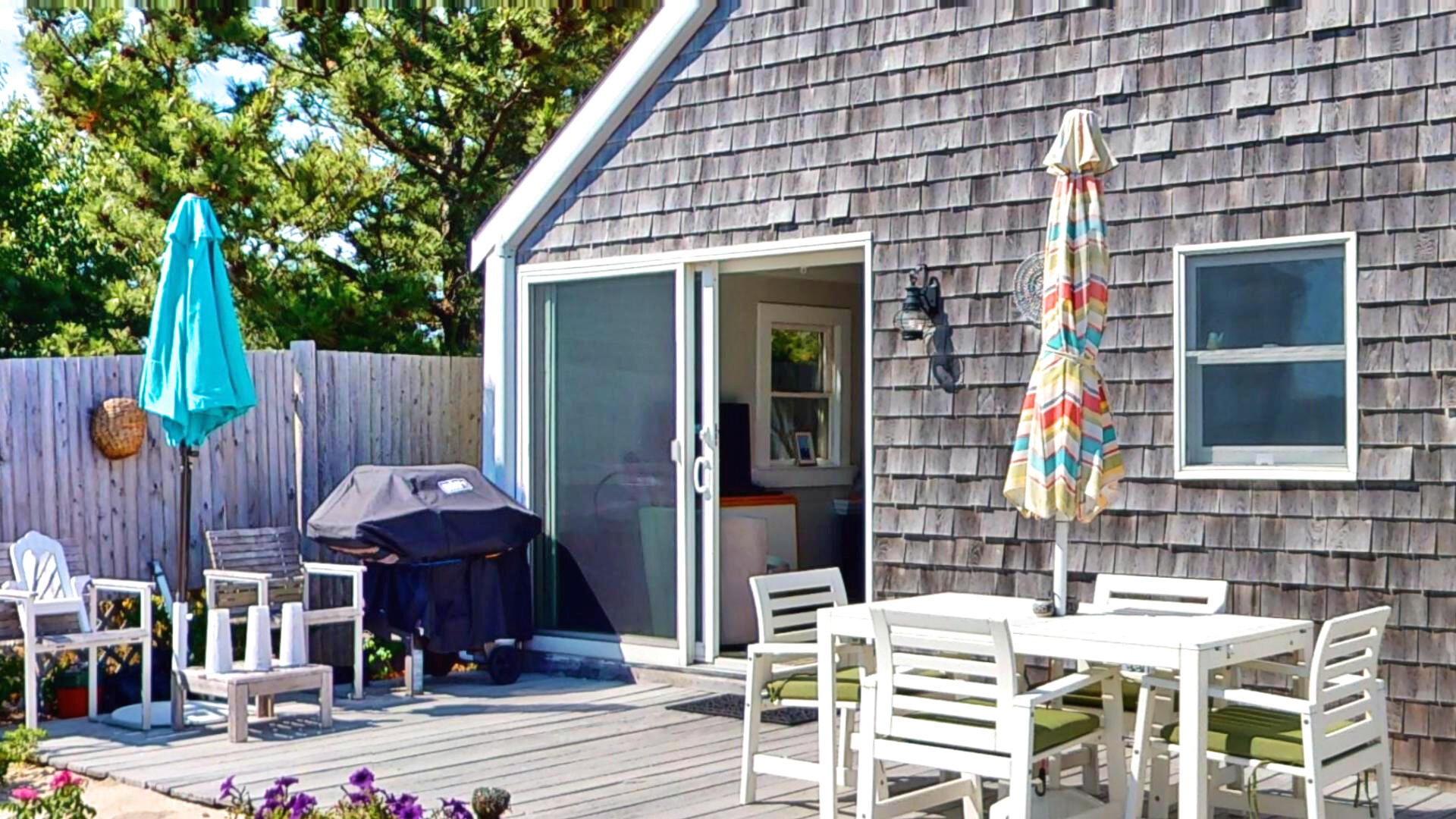 596 Shore Road, Unit H Truro, MA 02666 - Photo 2 of 30 a view of a patio with table and chairs with wooden fence and plants