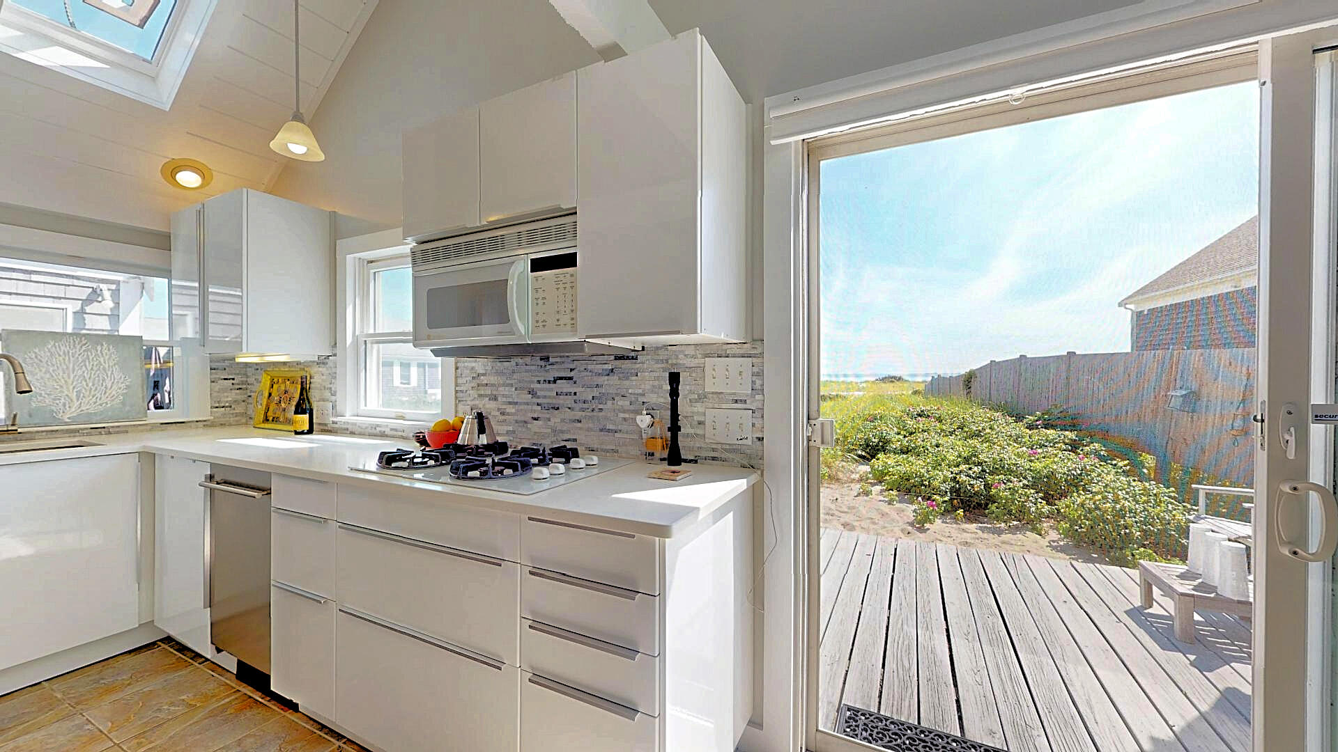 596 Shore Road, Unit H Truro, MA 02666 - Photo 10 of 30 a kitchen with a sink stove and cabinets